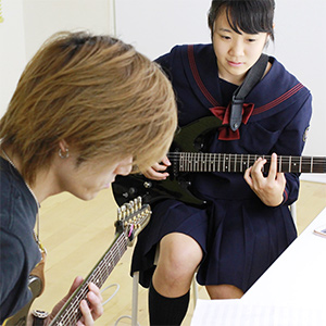楽器を教えるギタートレーナー